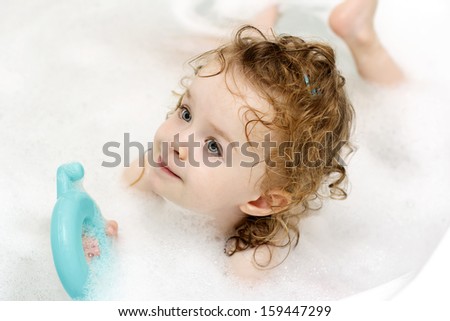 Little girl swimming in the bath