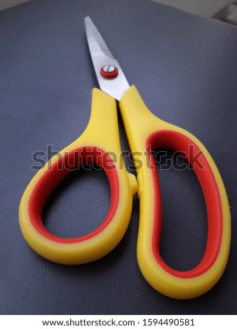 A picture of yellow and red scissor with a different angle