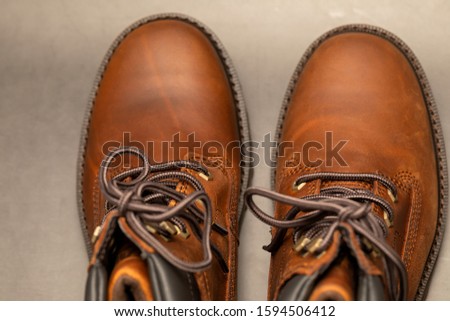 Brand new brown winter boots on gray background
