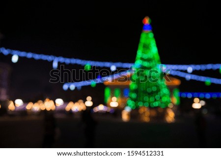 Blur colorful Christmas tree and gold bokeh in snow fall, festive theme panoramic banner background