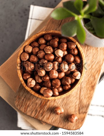 A handful of peeled hazelnuts, hazelnuts on a wooden plate close-up.