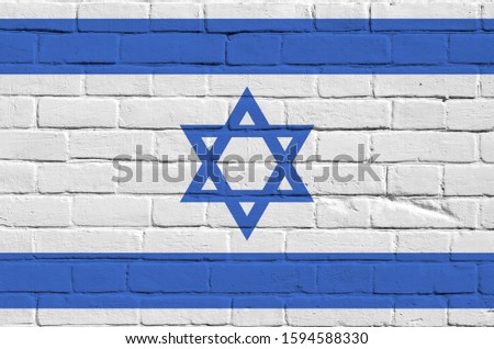 Israel flag depicted in paint colors on old brick wall. Textured banner on big brick wall masonry background