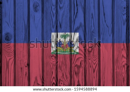 Haiti flag depicted in bright paint colors on old wooden wall. Textured banner on rough background