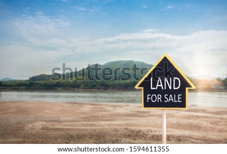 land for sale sign against trimmed lawn background. Empty dry cracked swamp reclamation soil, land plot for housing construction project in rural area and beautiful blue sky with fresh air.