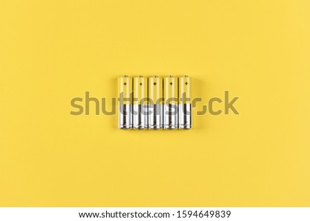 Photo of five gray-yellow alkaline AA batteries on a yellow background. Recycling of rechargeable NiMH batteries. The most popular size of accumulators. Copy space. Royalty-Free Stock Photo #1594649839