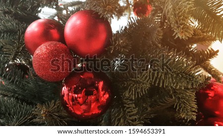Red Christmas ball on Christmas tree. Horizontal image close up and selective focus red wrinkle Cristmas ball hanging on Cristmas tree for celebrate. New year decorations and red ball.