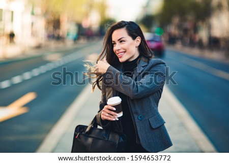 Happy beautiful professional business woman outdoors holding disposable paper cup.