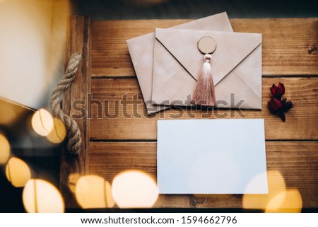 White blank on a wooden background with bokeh and dried flowers. Loft style. New Year's note or letter to Santa Claus. 