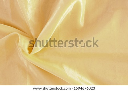 Light yellow silk fabric. Textile Background Texture. Expensive material. High resolution. Abstract waving fabric.