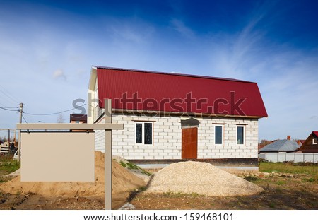 sign on the background of a house under construction