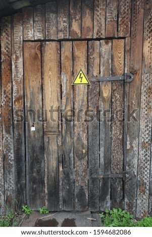 A wooden door and a danger sign on it