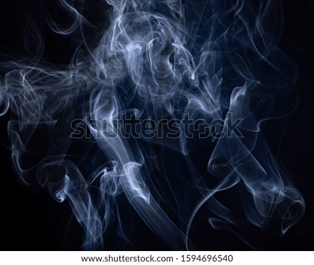 A close up macro photo of incense smoke lit by a blue flash to create a moody glow overlay