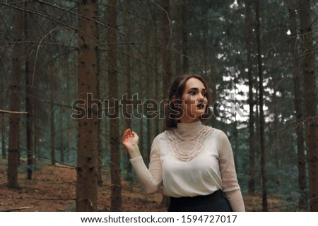 Beautiful and young girl with a lantern in the forest. Fairytale atmospheric photo.
