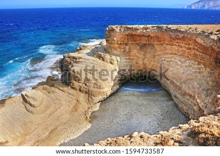 the famous Gala beach at Ano Koufonisi island Greece - the sea enters the beach via a narrow corridor of the open cave of the rocks - Gala means milk in the greek language Royalty-Free Stock Photo #1594733587