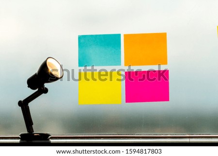 Reminder notes bright color put on the glass window and lamp that is shining, Recording concept.