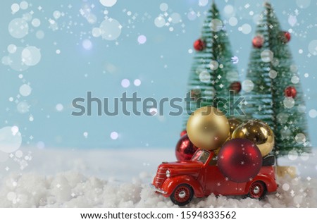 the concept of new year and Christmas. red car with Christmas balls on a blue background with Christmas trees.