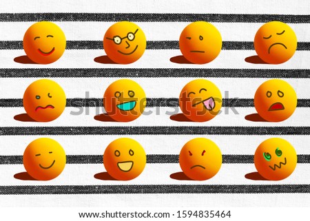 Concept of divesity with different emotions with cartoons face like sad angry happy unhappy smile illustrated on ping pong balls and white texture background with black striped.
