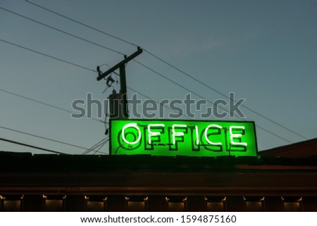 A Green Neon Office Sign at Night
