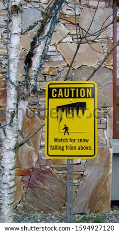 Caution. Watch for snow falling from above sign