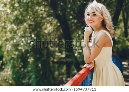 Stylish girl in a retro dress. Vintage lady in a summer park. Pretty woman in a yellow dress
