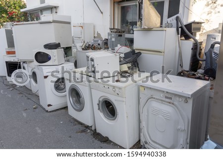 Collection place of old electric household appliances - broken and rusty microwaves, fridges, washing machines. Concept - ecological disposal, hazardous waste. Royalty-Free Stock Photo #1594940338