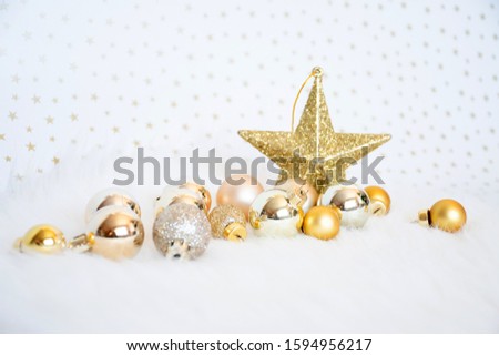 Object decorated, gold-yellow-gilter christmas ball on white fur with blackground burry star, merry chistmas and happy new year concept.
