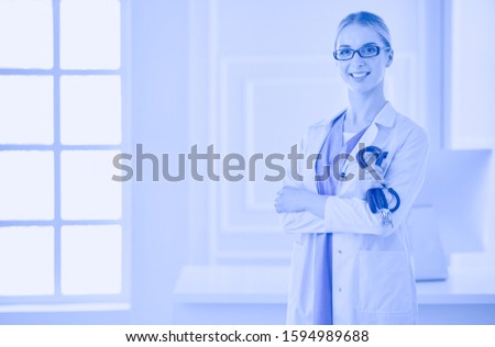 Cheerful happy doctor with crossed hands on blue background