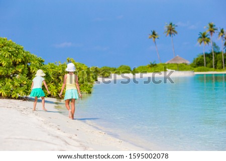 Little cute girls drawing picture on a beach