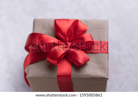 Brown gift box with red ribbon, grey background flat lay for stock image.  