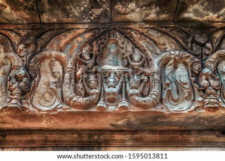 Banteay Srei Srey sanctuary temple Citadel of Women of beauty intricacy of the bas relief carvings walls buildings. Many niches in the temple Mural wall contain carvings of devatas or dvarapalas. 