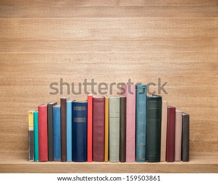 Old books on a wooden shelf. 
