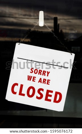 Sorry we are closed sign hanging on a window