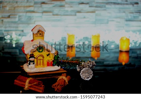 Festive day, cozy background, New Year's house on a black background with cones with silver, with cinnamon. The concept of home atmosphere and comfort.