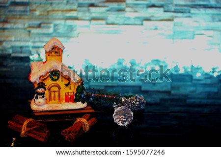 Festive day, cozy background, New Year's house on a black background with cones with silver, with cinnamon. The concept of home atmosphere and comfort.