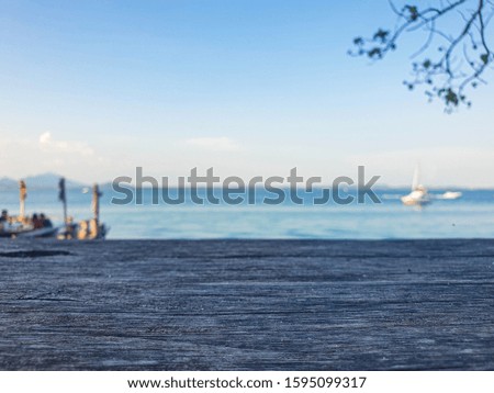Picture of a wooden table with a blurry background in the sea The atmosphere in the morning and evening is still sunny. Is a natural concept and has space for characters. Copy space. with glasses