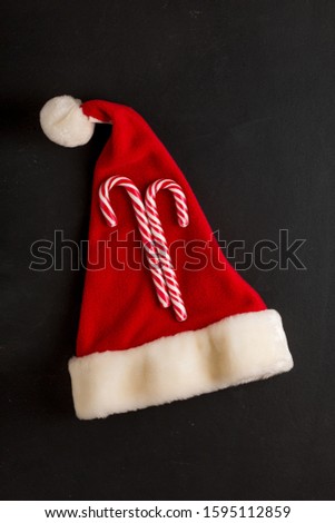 Santa Claus hat and Christmas Candy cane. New Year and Christmas symbols