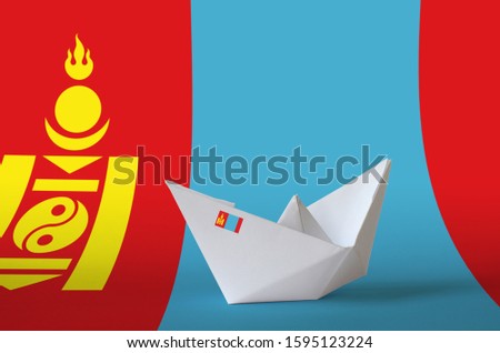 Mongolia flag depicted on paper origami ship closeup. Handmade arts concept