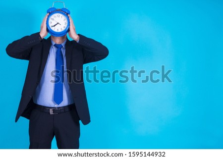 businessman with alarm clock in front of his face