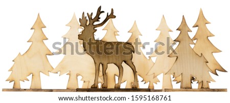 Cut out deer figure made of wood with dark edges and wooden fir trees isolated on white