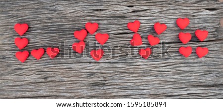 letter of love made from red heart shape on wooden background, love and valentine concept