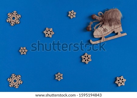 Christmas composition. Skates and snowflakes on a blue background. Flat lay, copy space, new year, top view, minimal.