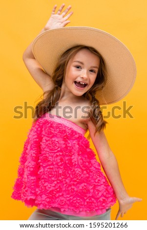 close-up portrait photo of happy cheerful charming beautiful young girl with a straw hat on her head on an orange background