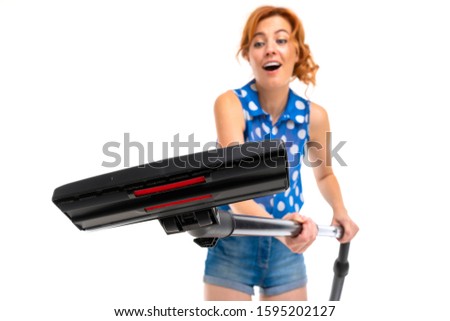European girl with a vacuum cleaner in hands on a white background