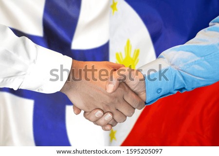 Business handshake on the background of two flags. Men handshake on the background of the Finland and Philippines flag. Support concept