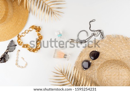 Straw hat and sunglasses top view on white background