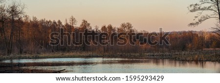 Deciduous forest and lakes at sunset. Spring season, March. Web banner.