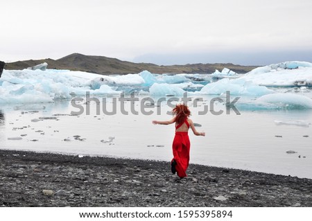 Land of Ice and Fire: girl in red dress in Jökulsárlón glacier lagoon in Iceland