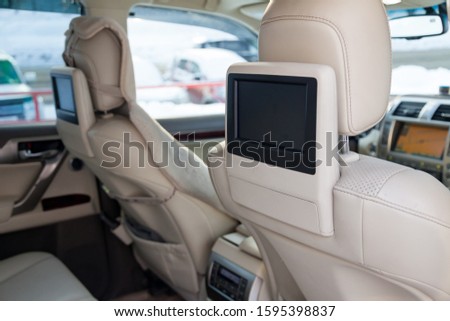 Entertainment system for rear passengers in a car with two monitors mounted on the backs of the front seats for watching TV, cartoons and computer games.