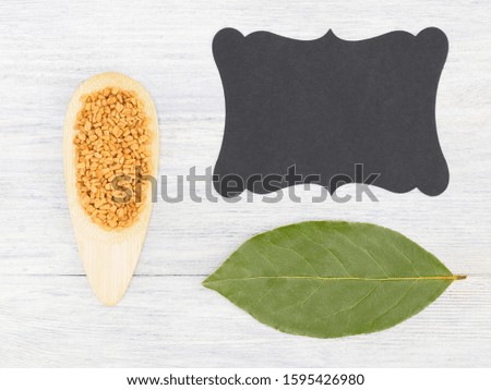 Fenugreek, bay leaf, nameplate on a white concrete background with copy space