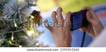 close up and soft focus hand of asian woman A woman with a camera to take photos of christmas decorative tree